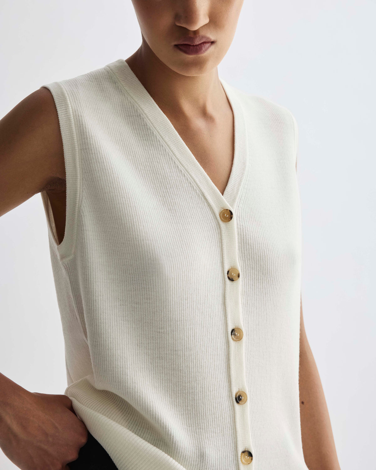 Ivory ribbed knit sleeveless V-neck cardigan with brown tortoise buttons