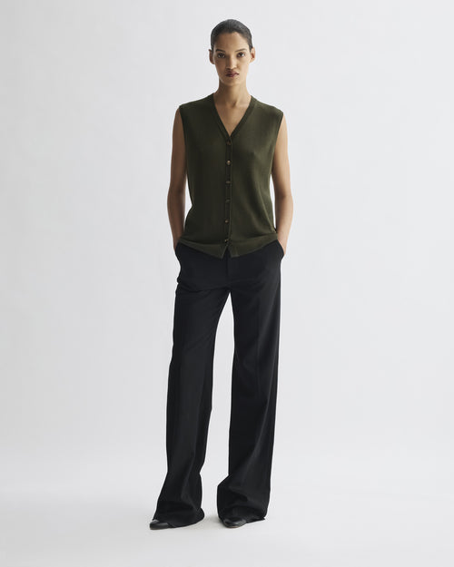 Alice Vest olive merino wool fitted sleeveless knit vest. V-neck, precise shoulder line, horn buttons on model