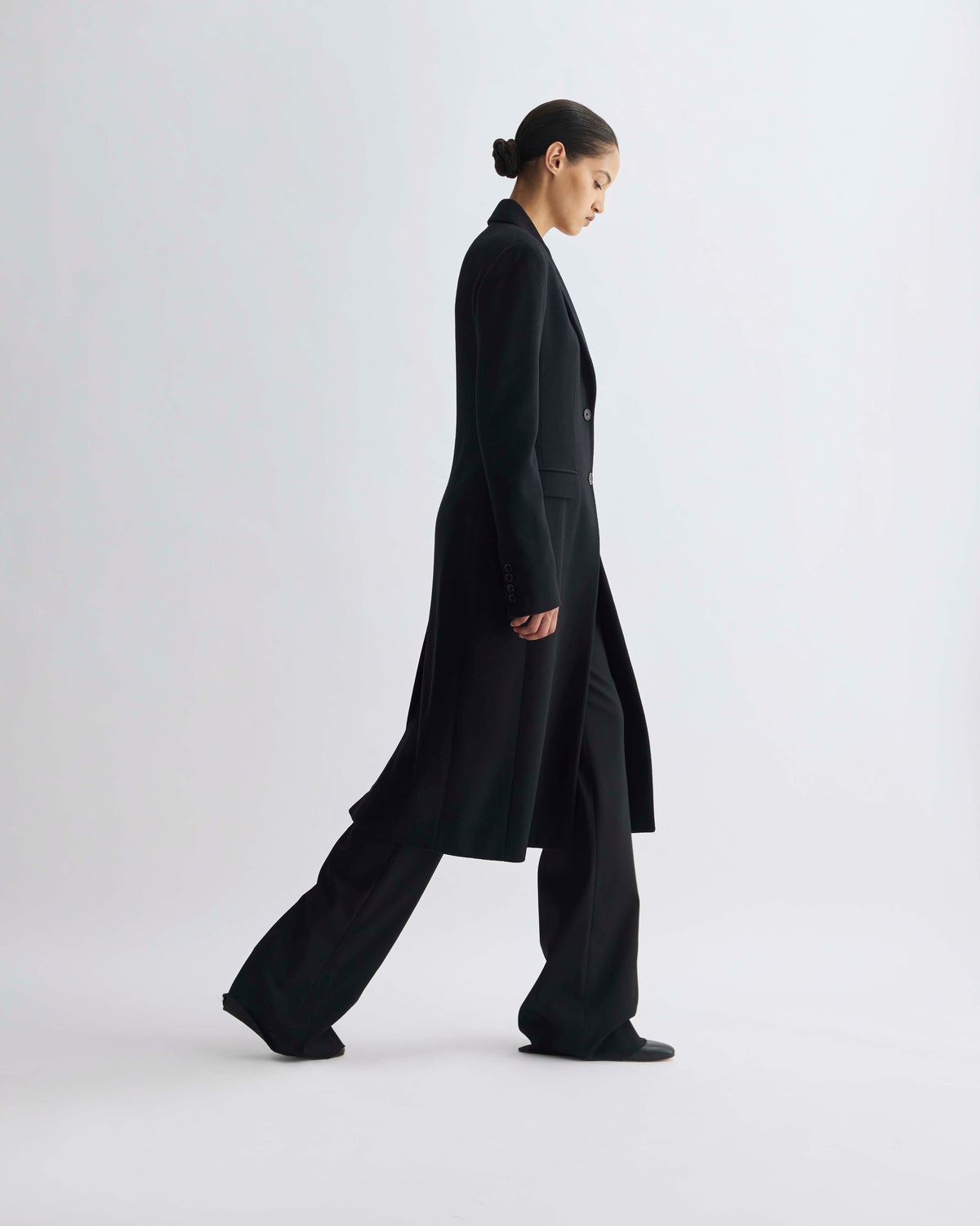 Luxury women's black tailored wool long coat and wide-leg trousers, elegant minimalist fashion on model