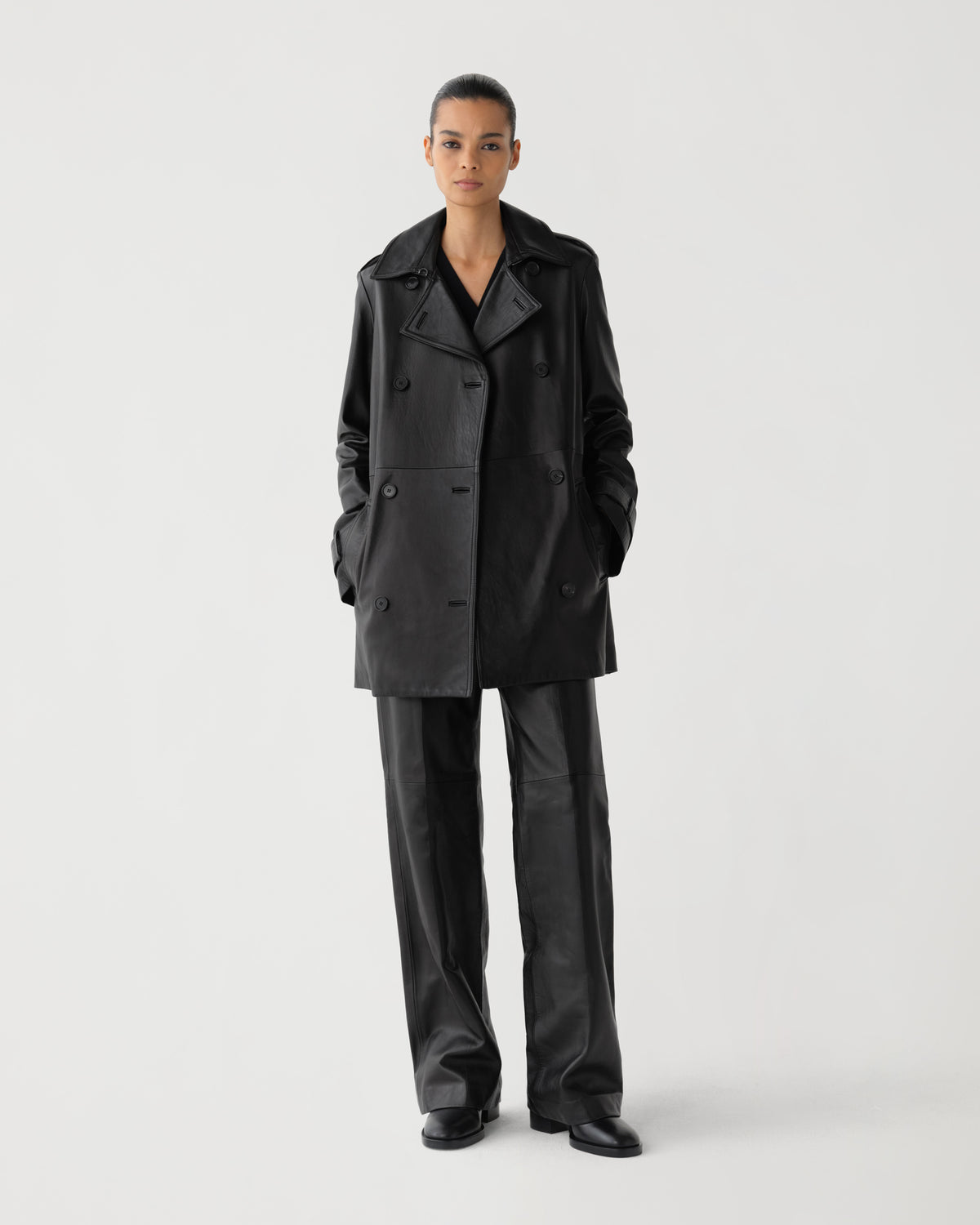 Women's black leather double-breasted coat, wide lapels, side pockets, paired with wide-leg leather trousers