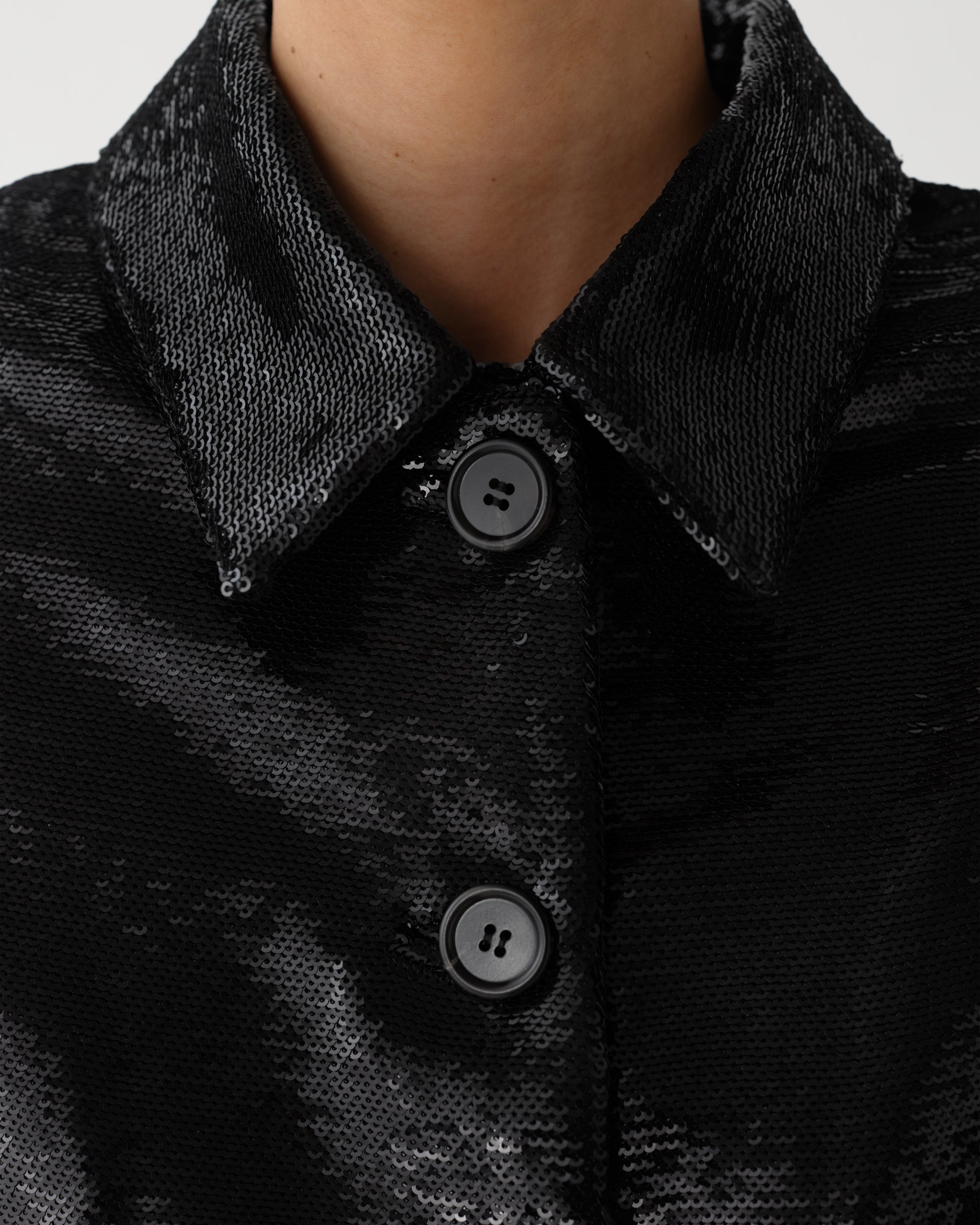 Black Ines Jacket in flat sequin by Veronica De Piante, showcasing a stylish coat with shimmering sequin details.