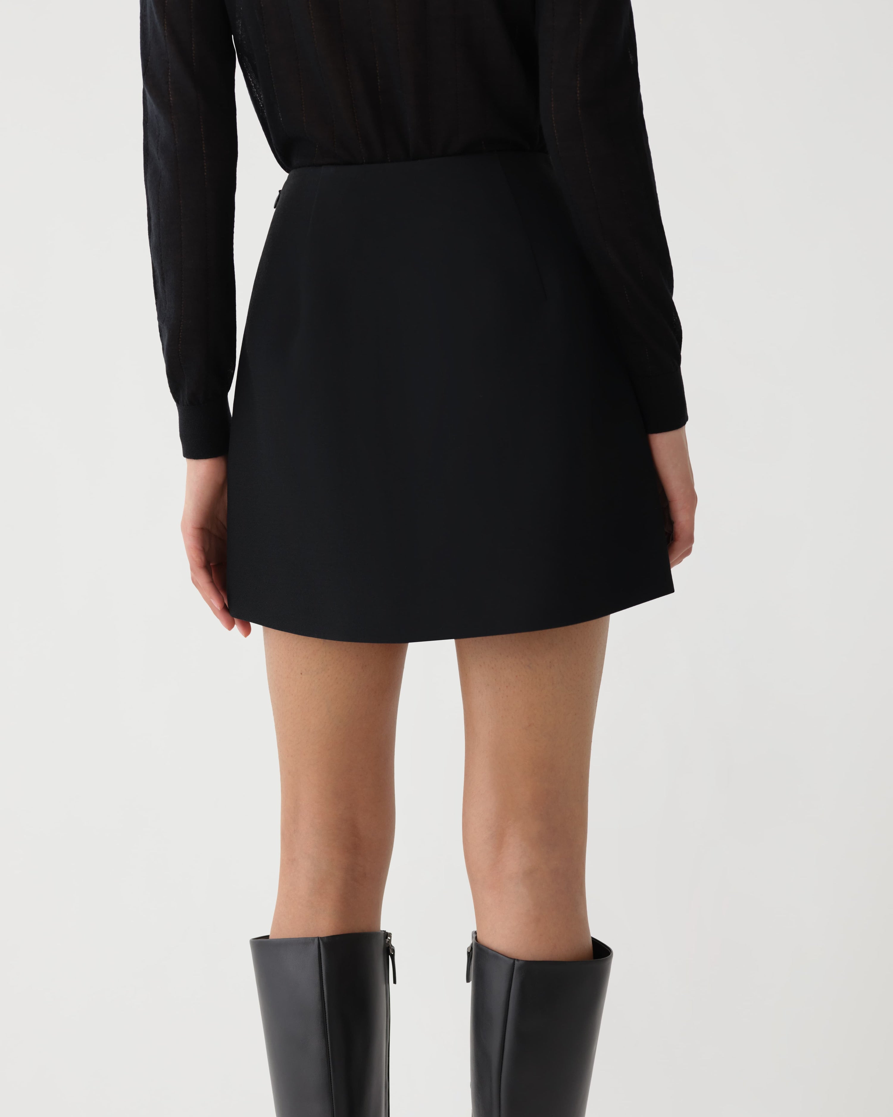 Black Cecily miniskirt in wool viscose fabric by Veronica De Piante, shown on a model, highlighting its sleek, fitted design.