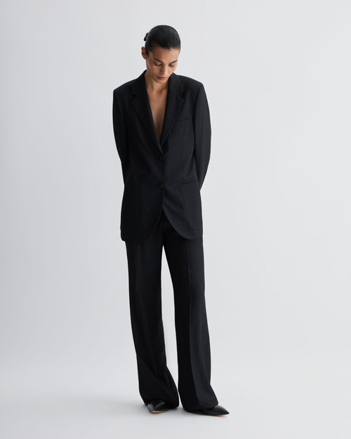Black silk Taylor Trouser, straight-leg, mid-rise fit. Model wearing trouser with matching Sebastian jacket, menswear-informed tailoring.