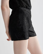 Black Helena Shorts in stretch sequin by Veronica De Piante, close-up of shiny, fitted bottoms with sequin detail.