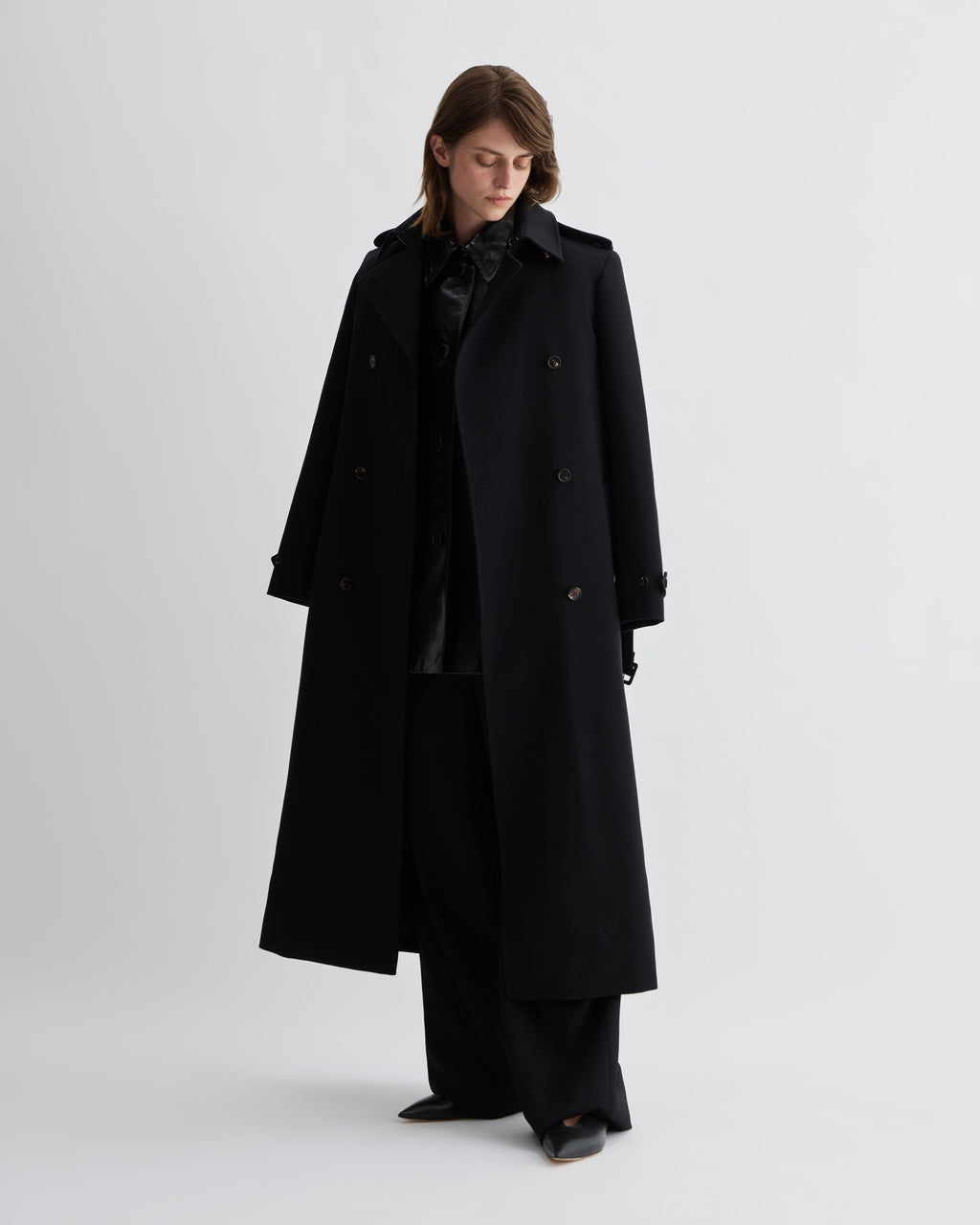 Black patent leather Jess Jacket by Veronica De Piante, stylish coat with a sleek, shiny finish and modern design.