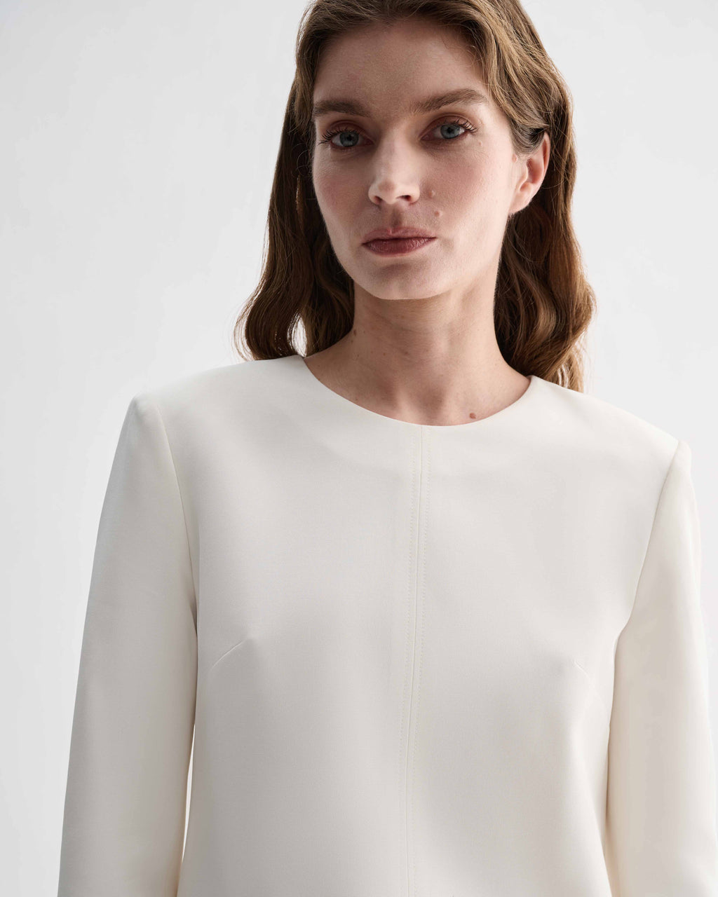 Off-white silk Ambar Tunic top by Veronica De Piante, displayed on a hanger with soft fabric details visible.