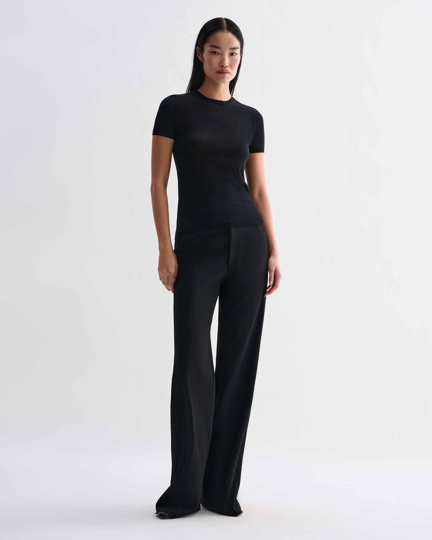 Black Bea Knit Top made from superfine merino wool by Veronica De Piante, shown on a model with a close-up of the fabric texture.