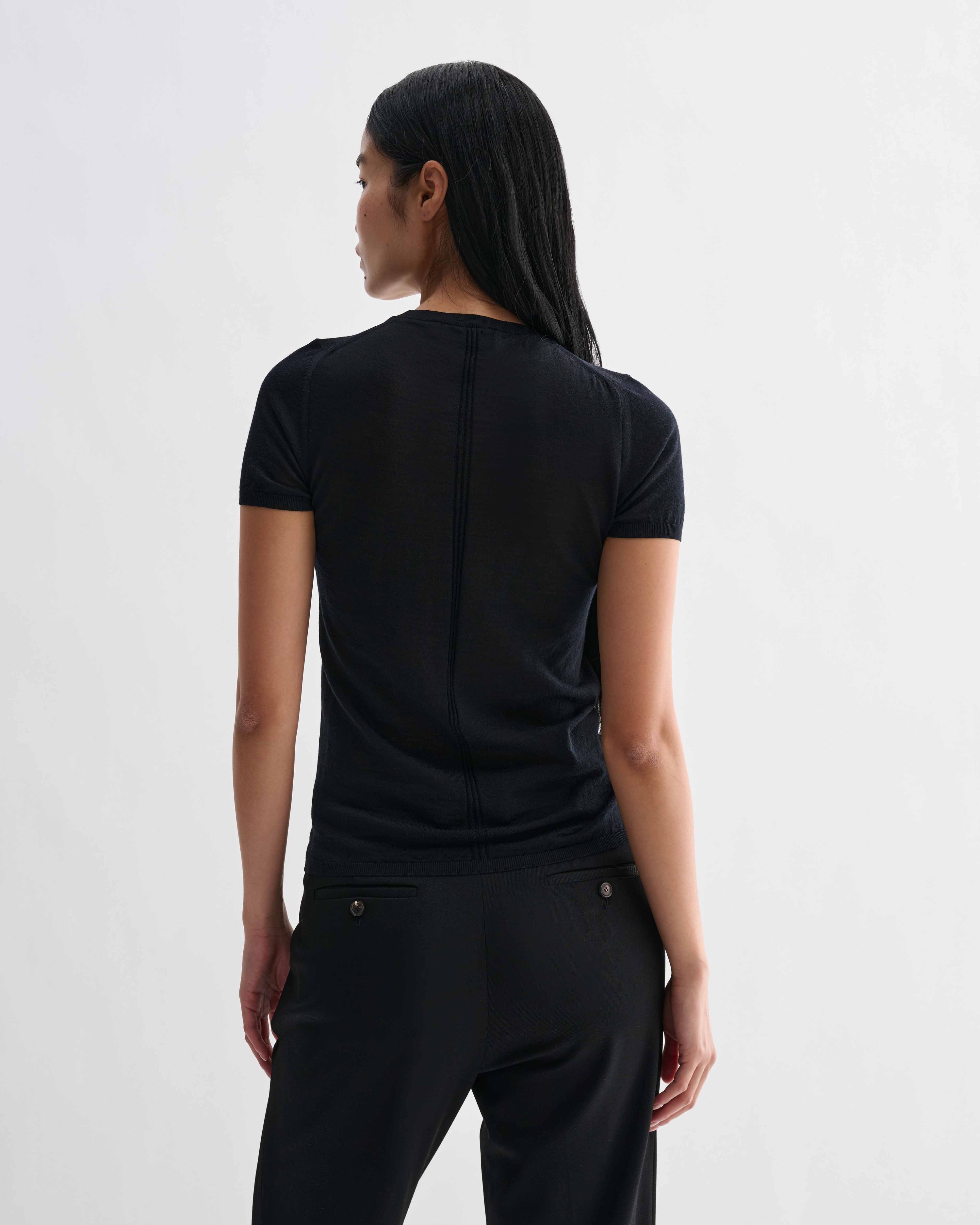 Black Bea Knit Top by Veronica De Piante, made from superfine merino wool, shown on a model with long sleeves and a fitted design.