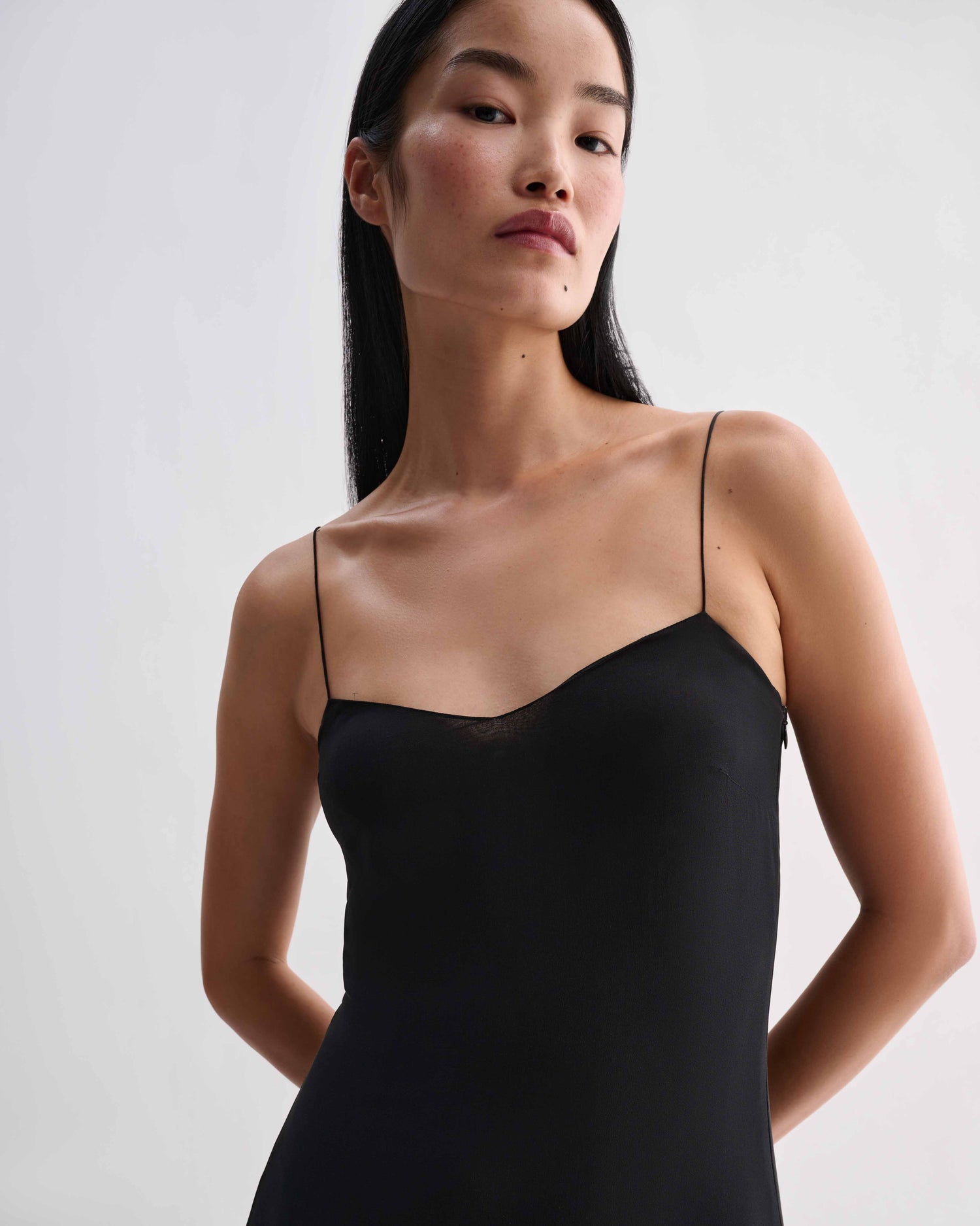 Black Calista Dress in Georgette by Veronica De Piante, shown on a mannequin with flowing fabric and elegant design.