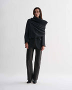 Charcoal wool cashmere Caro Snood knitwear on model. Dense gauge knitted shawl, generously draped over shoulders.