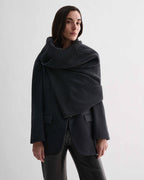 Caro Snood in charcoal wool cashmere knitwear on model. Dense gauge shawl wrapped at neck, settling on shoulders
