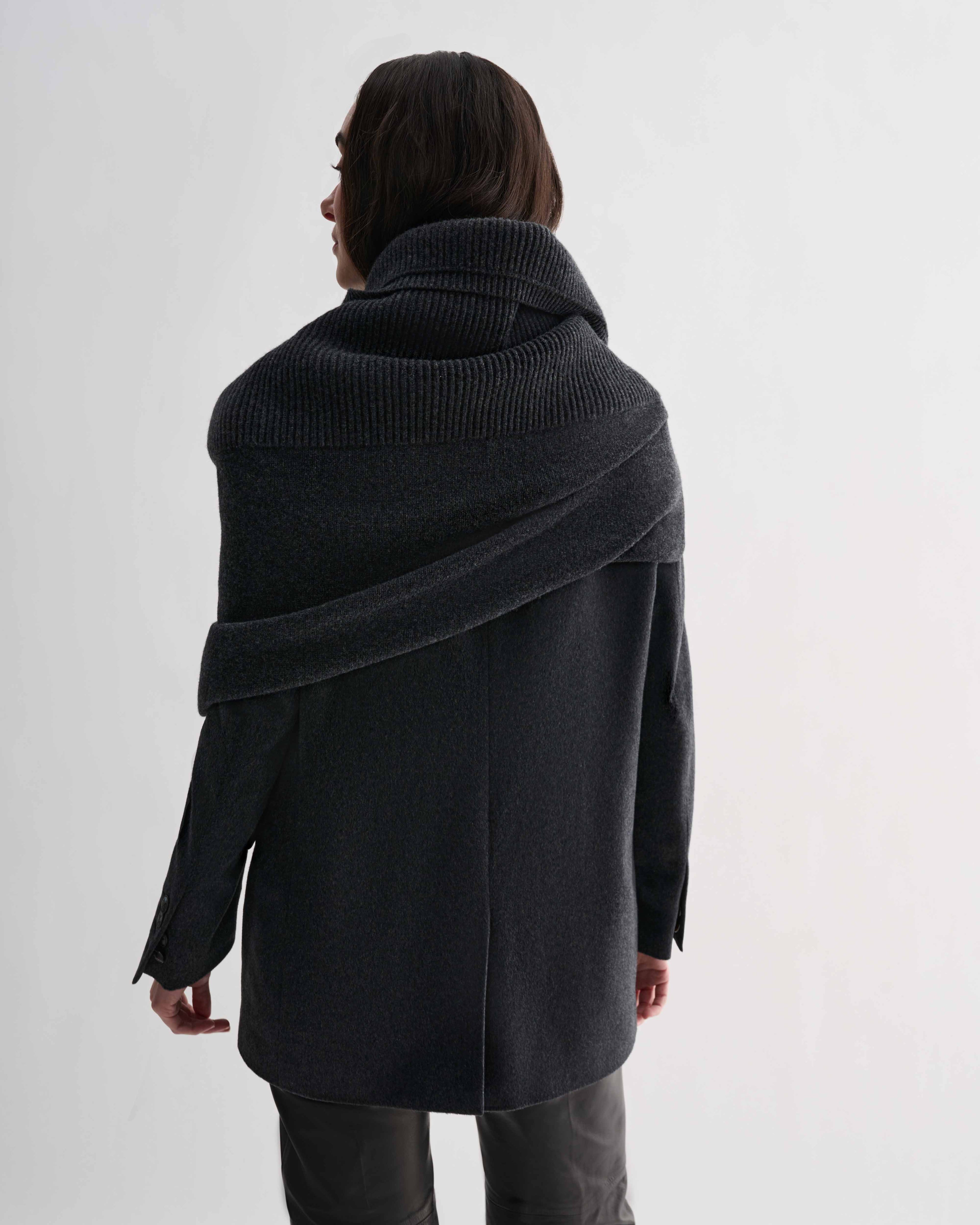 Charcoal Caro Snood, a generous wool cashmere knitted shawl, draped across model's shoulders and neck. Dense gauge knitwear