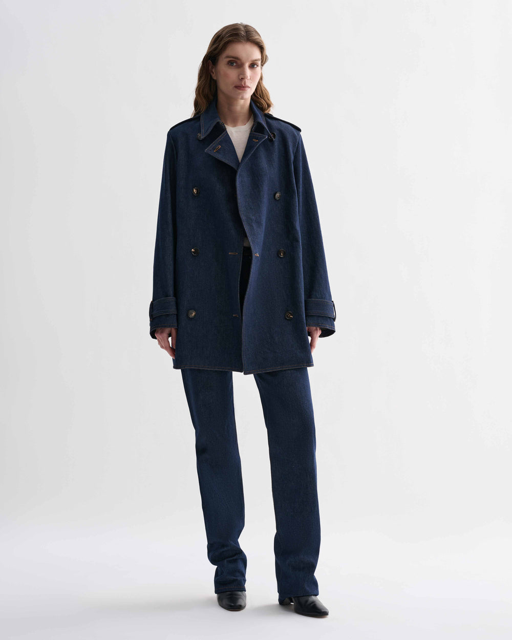 Blue Charlotte denim trench coat by Veronica De Piante hanging on a clothing rack with front view.