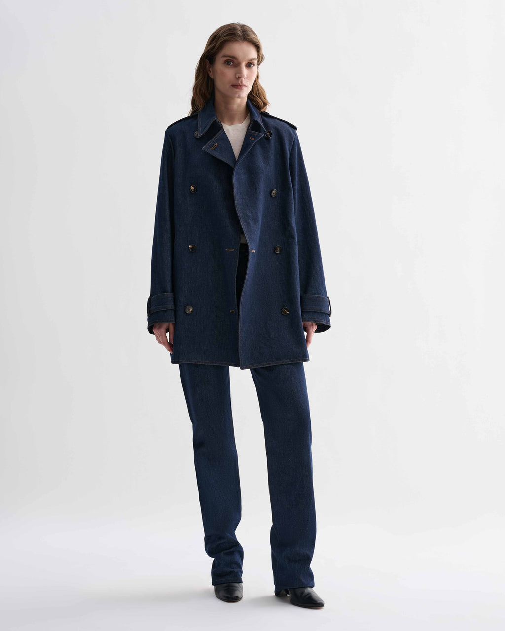 Blue Charlotte denim trench coat by Veronica De Piante hanging on a clothing rack with front view.