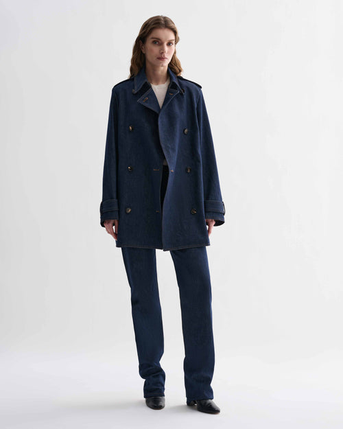 Blue Charlotte denim trench coat by Veronica De Piante hanging on a clothing rack with front view.