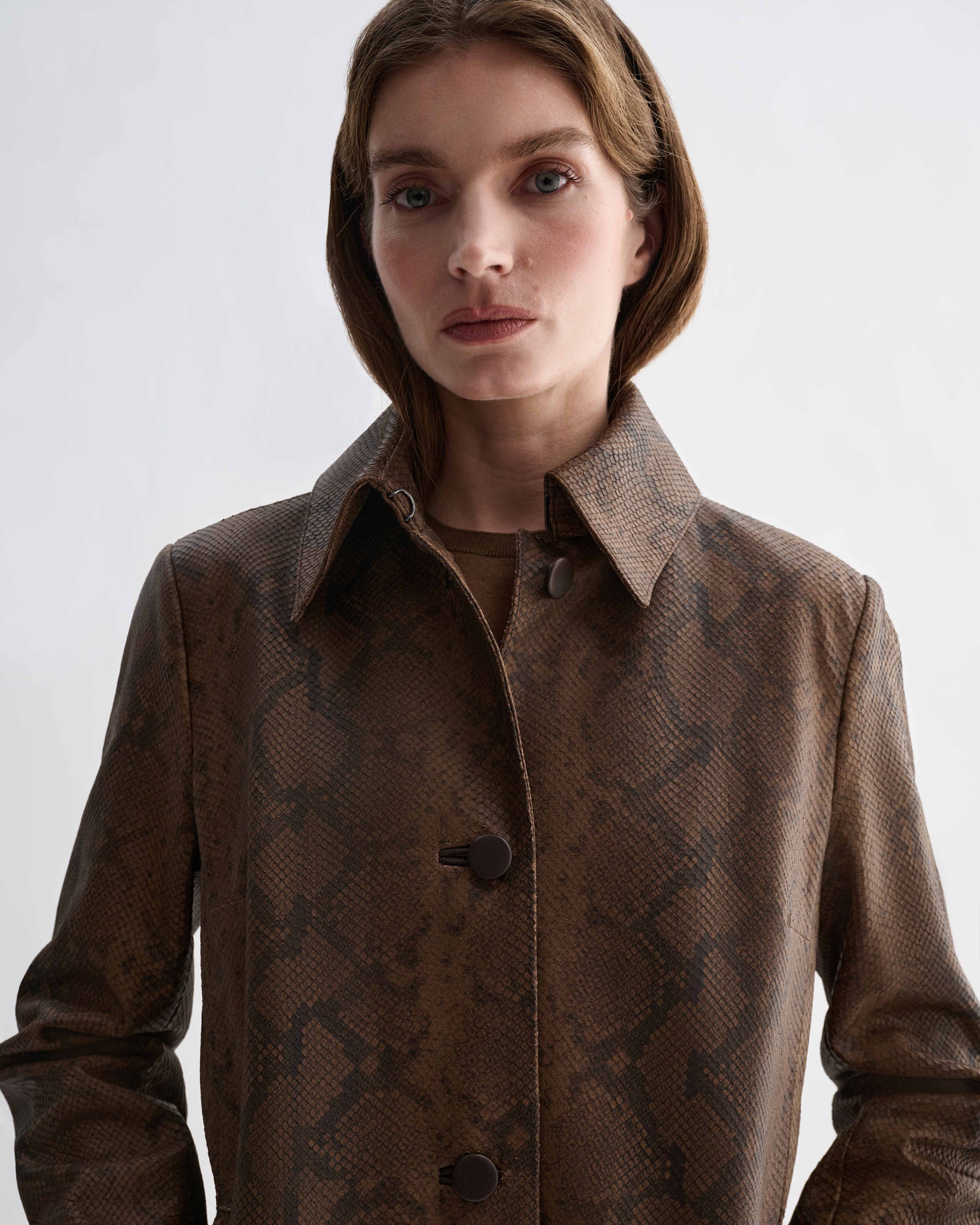 Tailored Chiara Coat in camel snake print embossed goatskin leather. Women's jacket with dark brown pattern, collar, and buttons