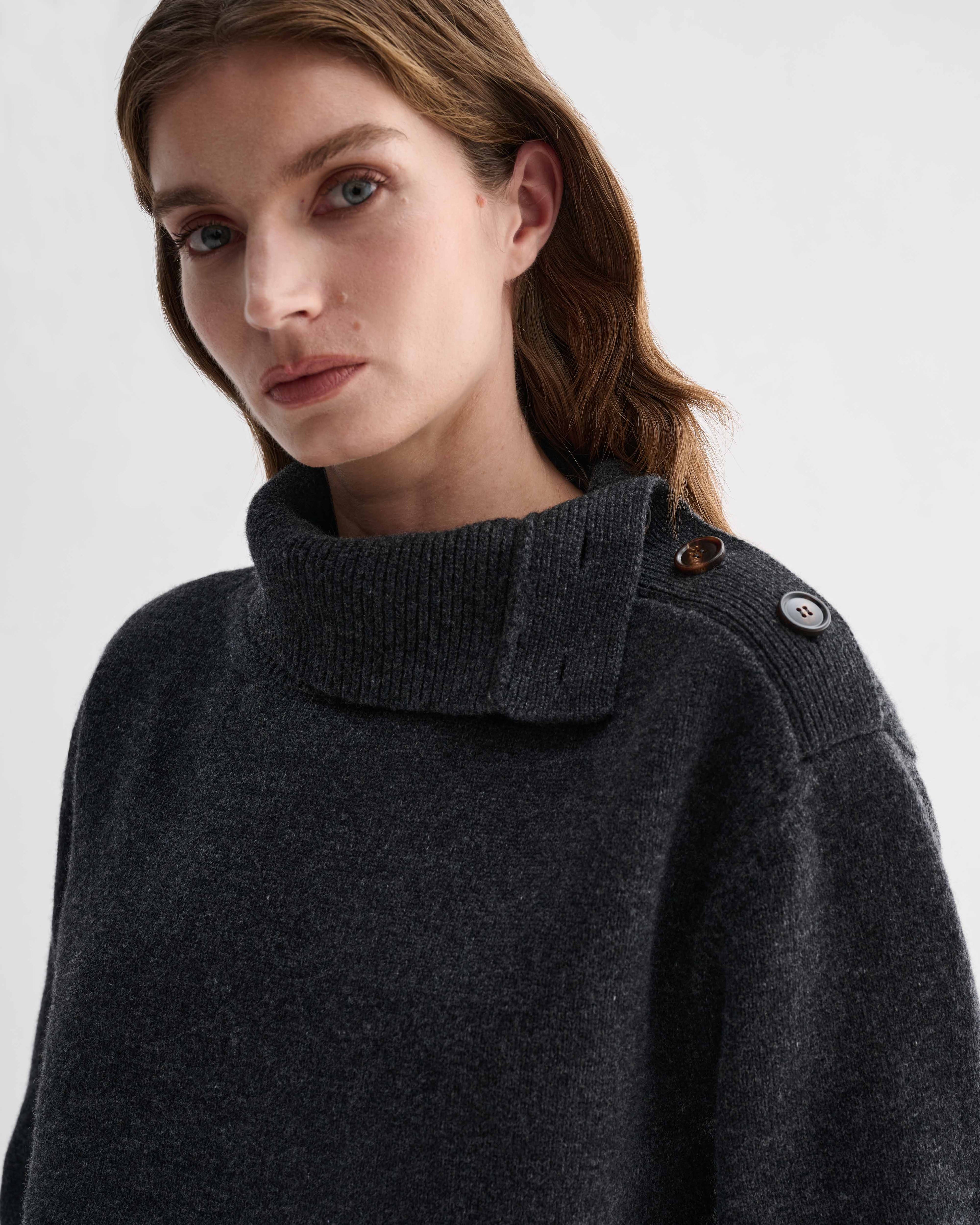 Cielo charcoal wool cashmere chunky knit sweater on model. Visible adjustable side buttoning neckline with dark horn buttons