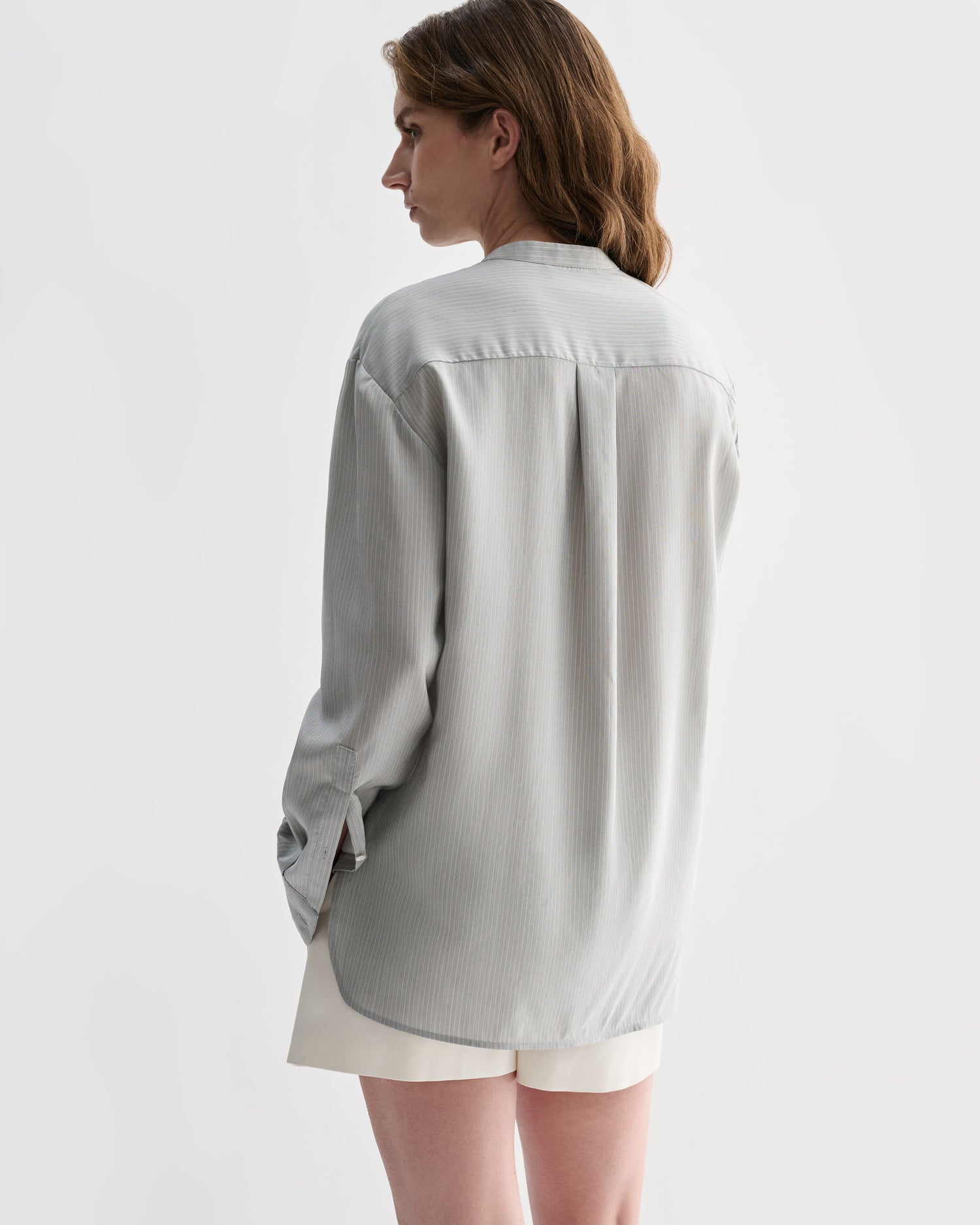 Grey pinstripe silk Daisy shirt by Veronica De Piante, shown with a close-up of the stylish, tailored top on a model.