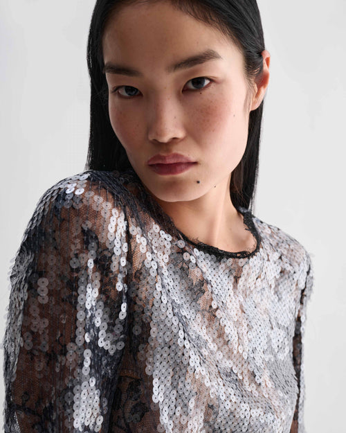 Dalia Top, black lace sequin crewneck top. Model wearing shimmering luxury evening top with dimensional texture