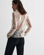 Gold Dalia Top in lace sequins. Sheer, long-sleeved luxury top with intricate texture and shimmer on model