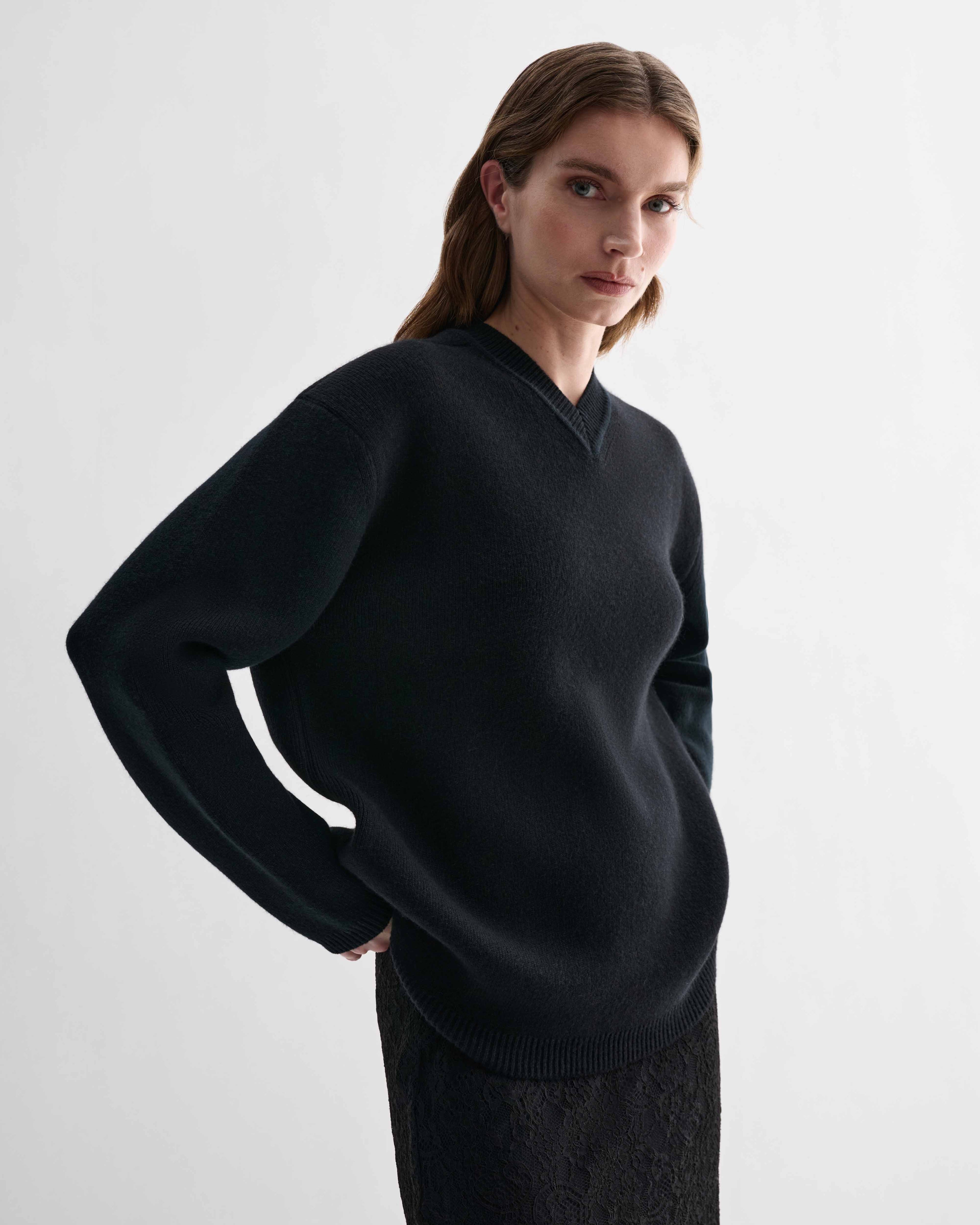 Elara Black Cashmere V-neck sweater on model. Elevated, dense knit, relaxed fit, eased shoulder luxury knitwear