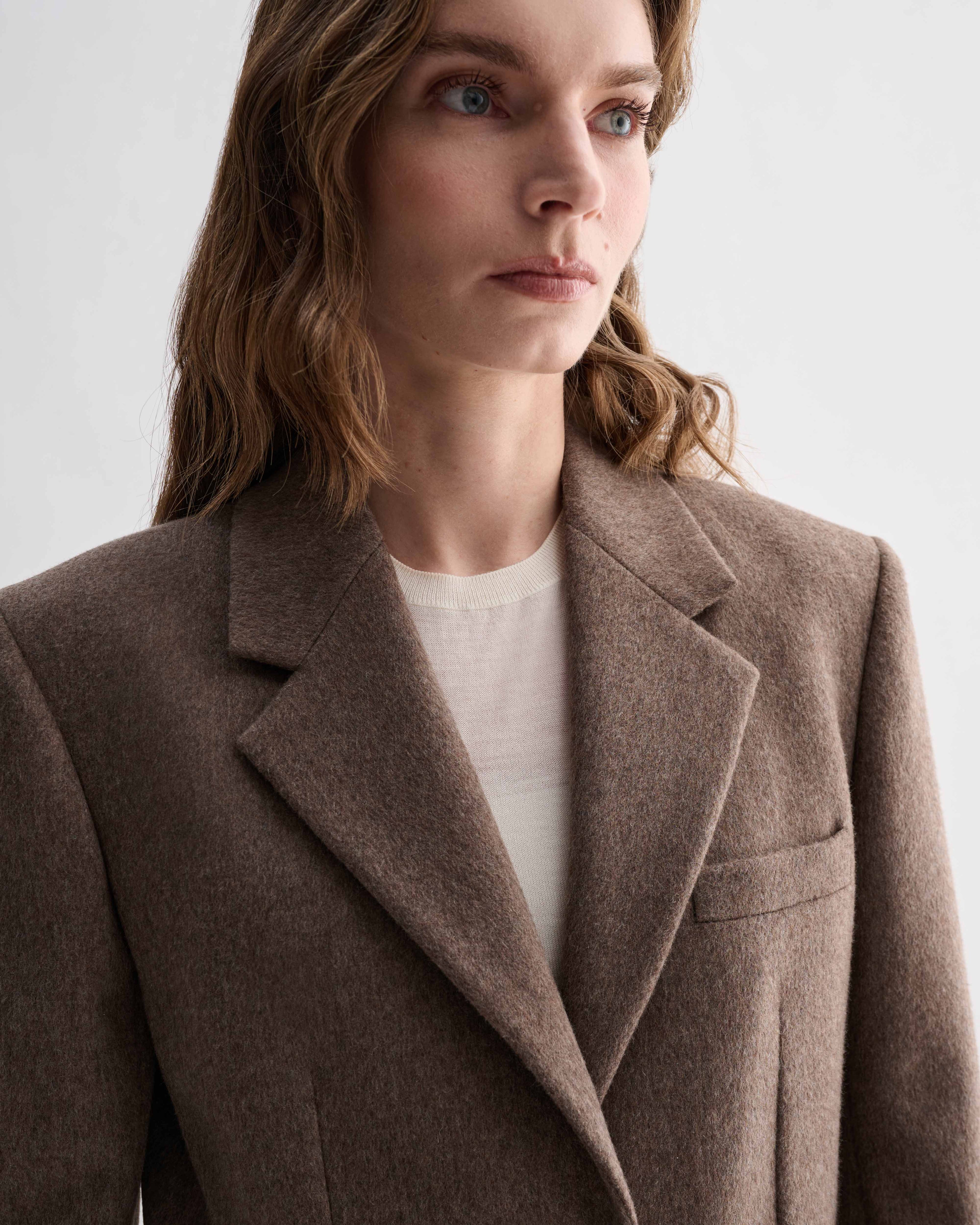 Freya Coat in oatmeal pure cashmere on model. Luxury Italian women's overcoat with broad shoulders and slouchy fit
