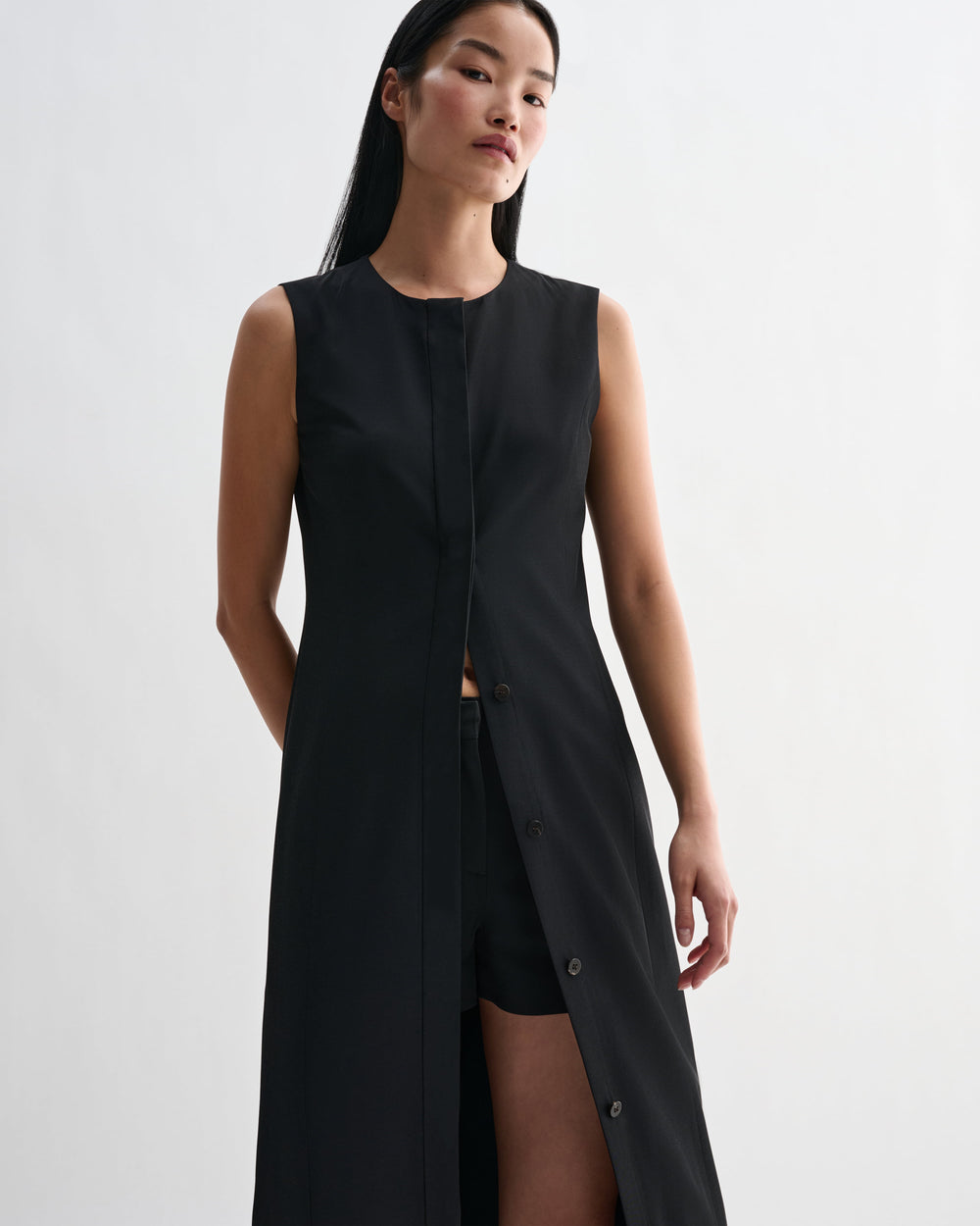 Black silk Hana Dress by Veronica De Piante, showcasing smooth fabric and elegant design in a close-up image.