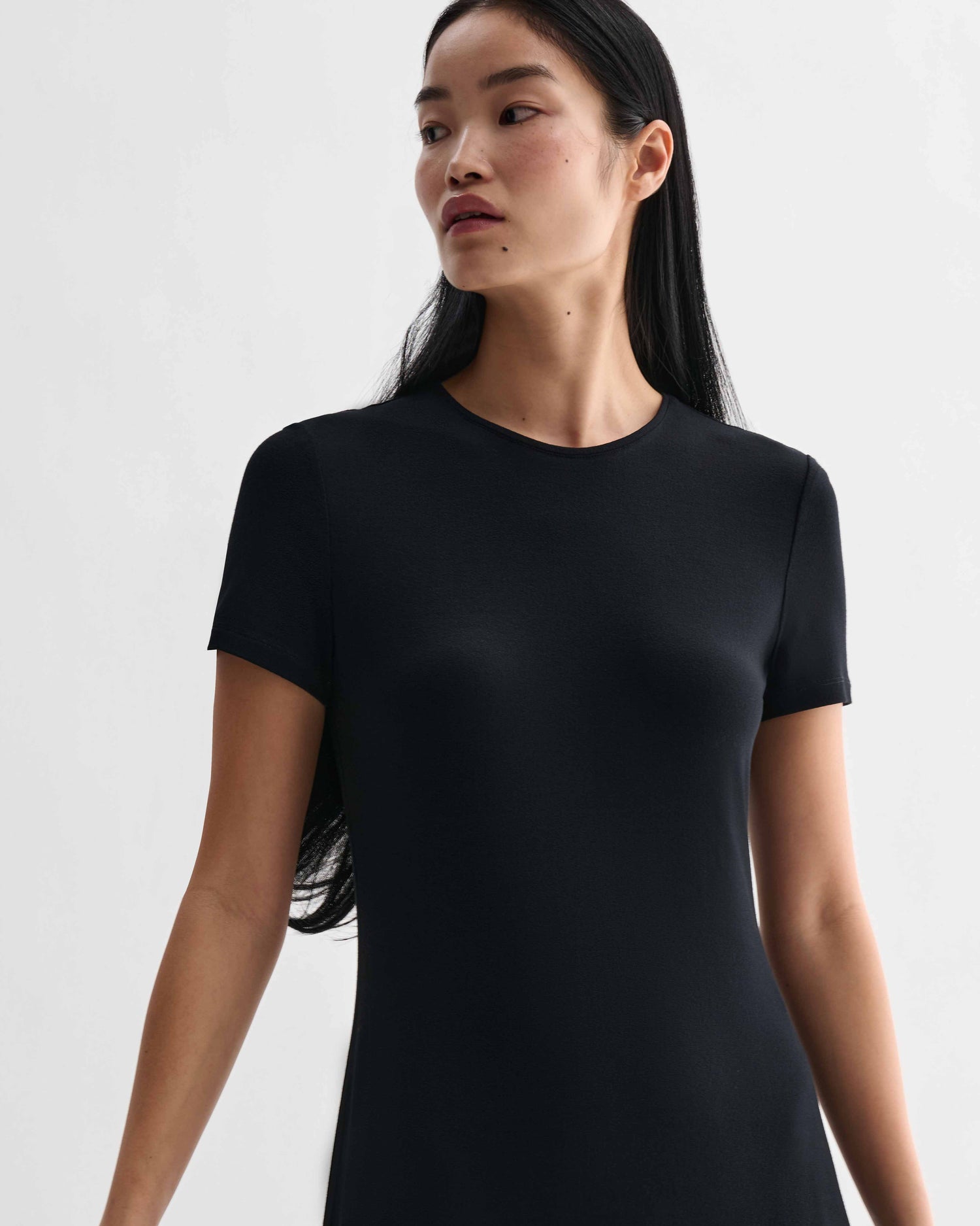 Black Harper dress by Veronica De Piante in stretch viscose jersey, shown on a model with a fitted silhouette and elegant neckline.
