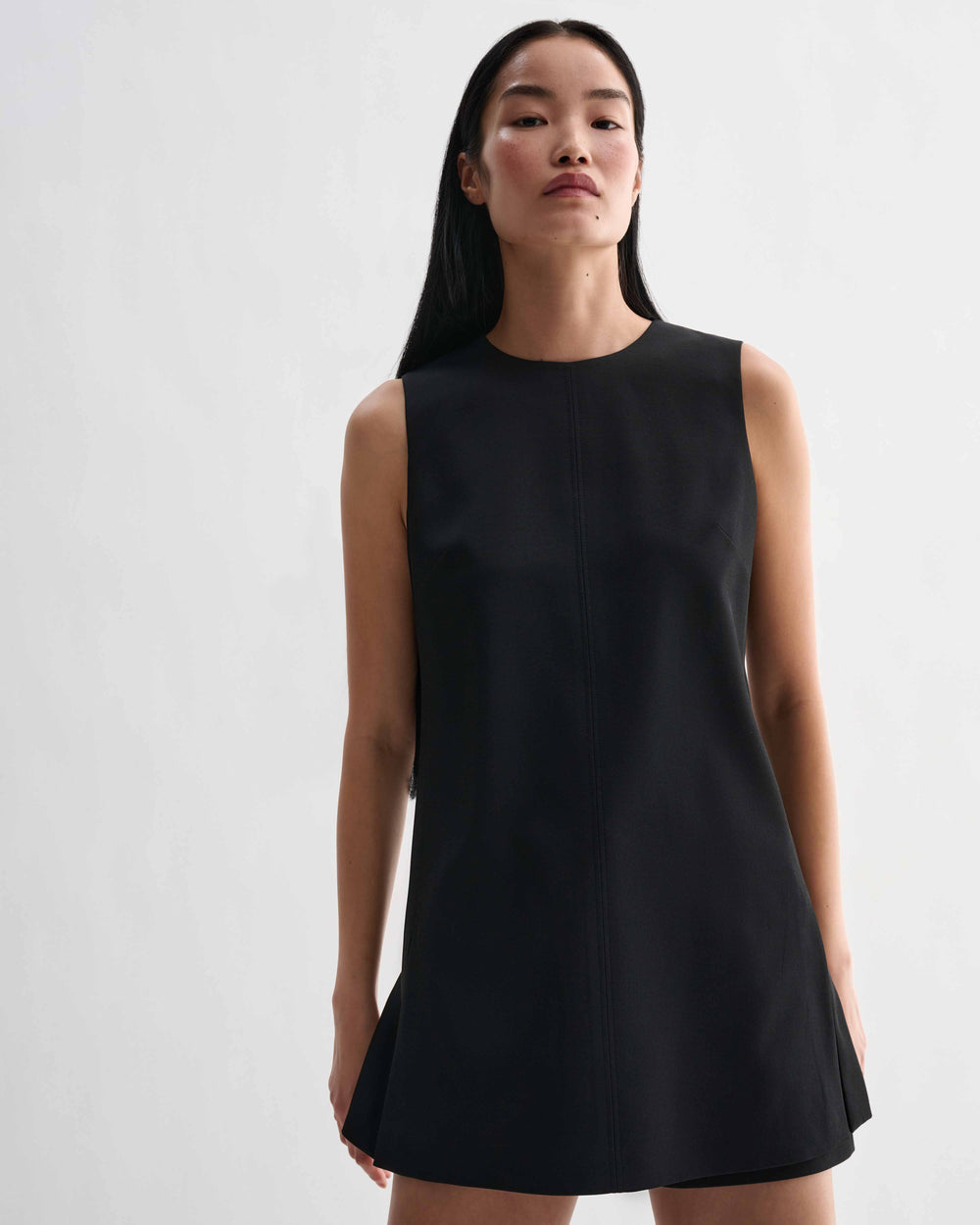 Black silk Honor tunic top by Veronica De Piante, displayed on a hanger with smooth fabric and minimalist design.