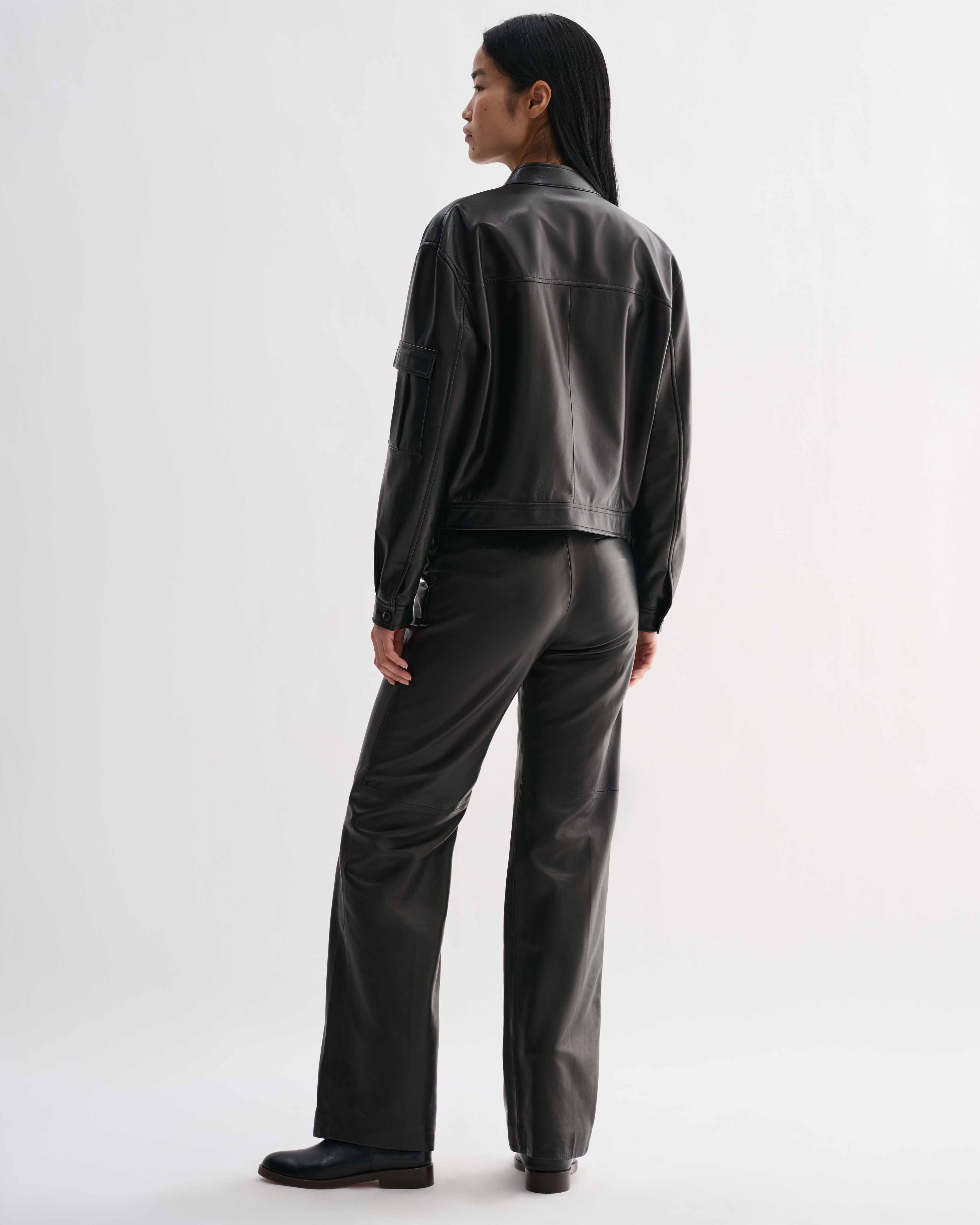 Veronica De Piante Juno Nappa Leather Black jacket displayed on a hanger, showcasing sleek design and smooth leather texture.