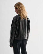 Veronica De Piante Juno black nappa leather jacket with sleek design, shown hanging on a hanger.