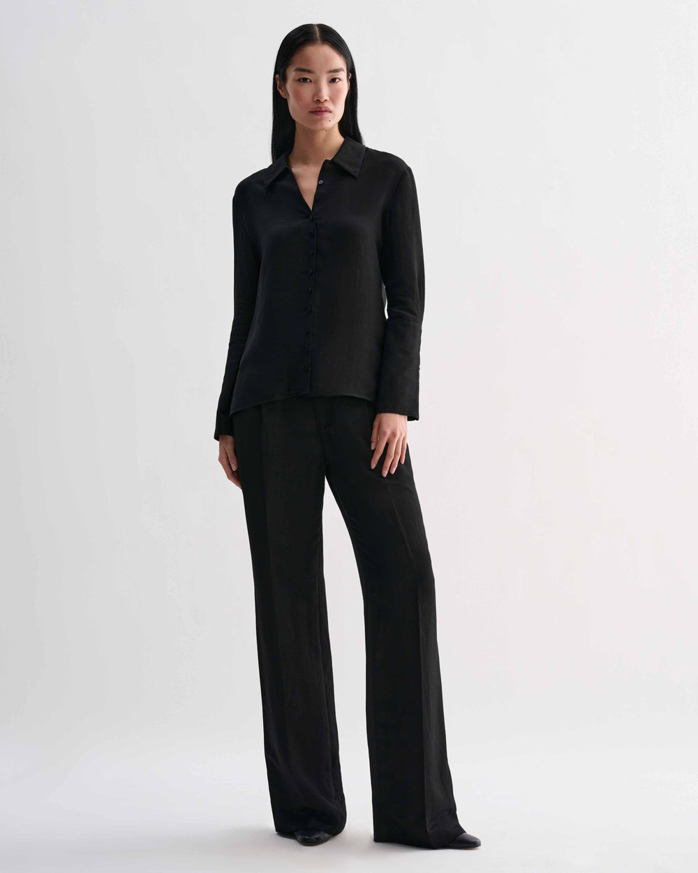 Black Livia linen shirt by Veronica De Piante, shown on a hanger with a relaxed fit and natural fabric texture.