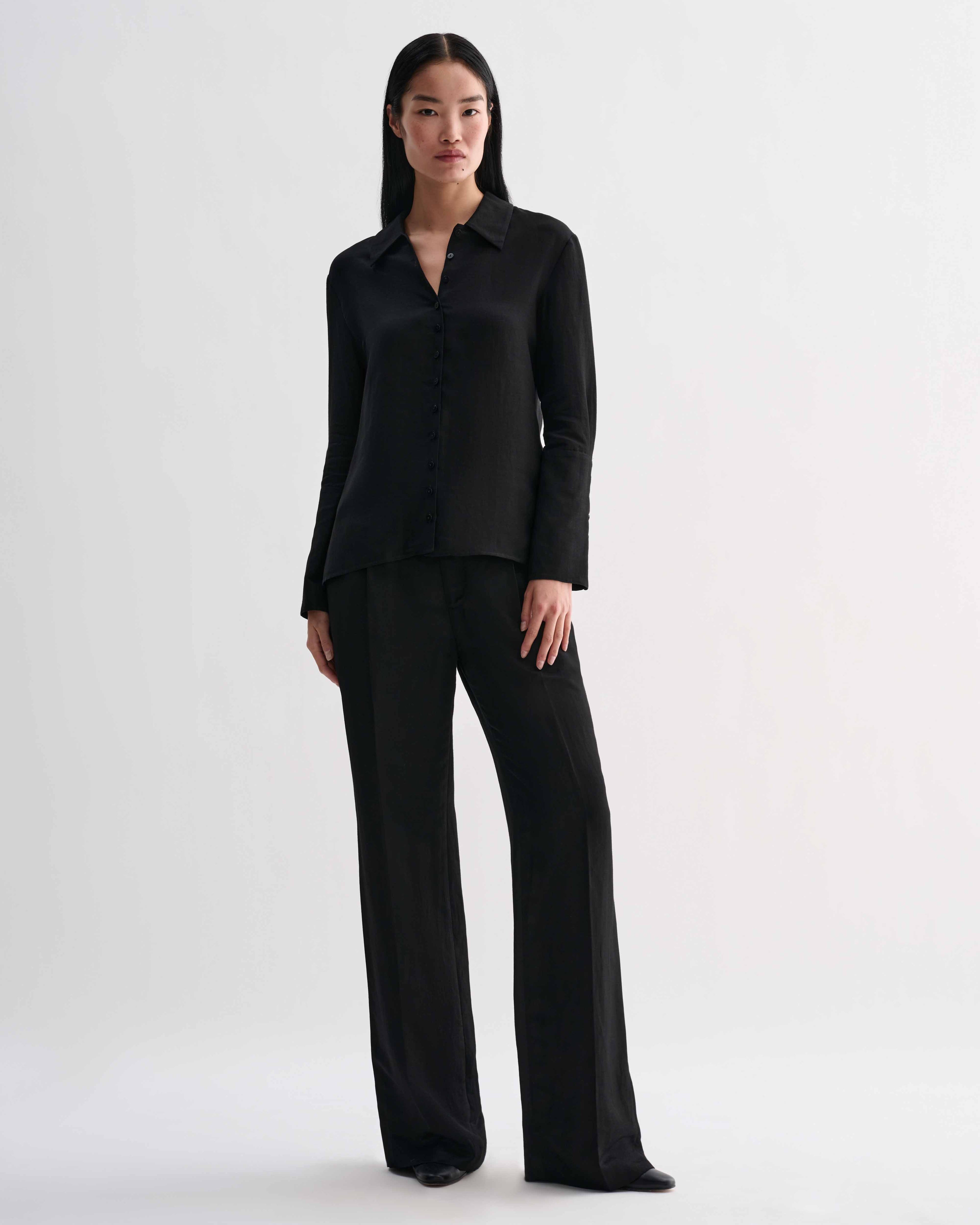 Black Livia linen shirt by Veronica De Piante, shown on a hanger with a relaxed fit and natural fabric texture.