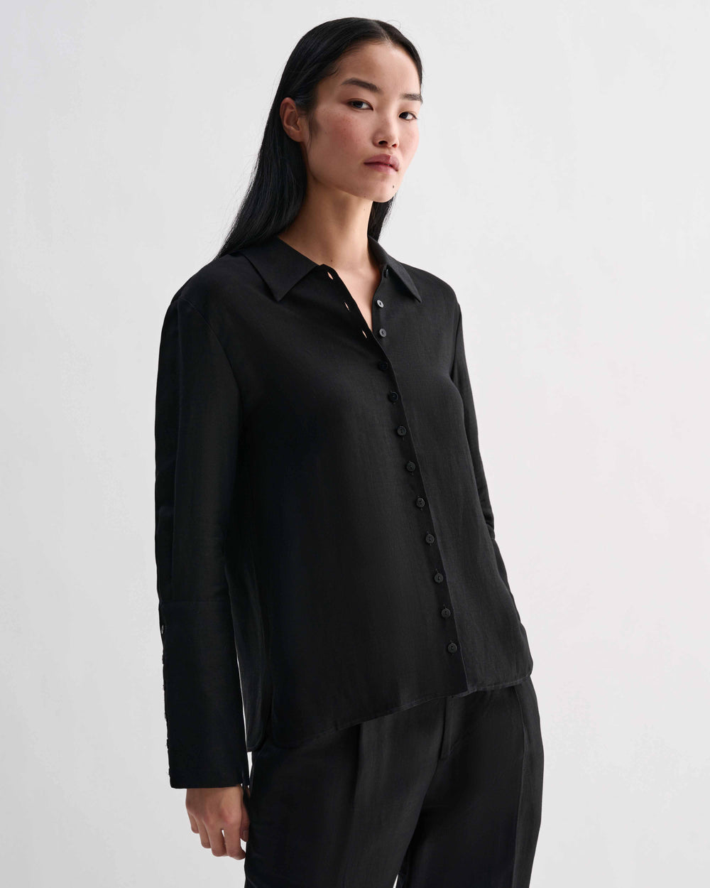 Black Livia linen shirt by Veronica De Piante, featuring a relaxed fit and stylish design, displayed on a hanger.