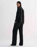 Black Livia linen shirt by Veronica De Piante, featuring a relaxed fit and stylish design, displayed on a hanger.