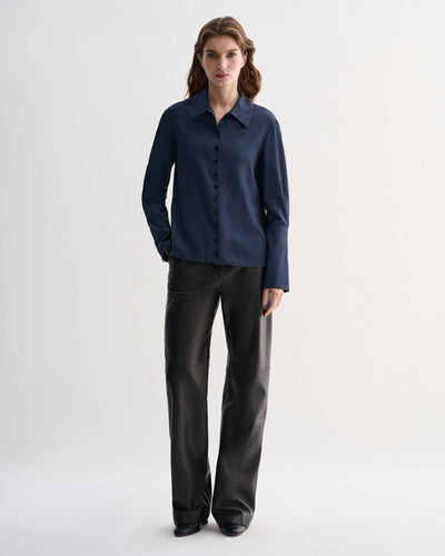 Female model wearing Livia Shirt in Petrol Blue silk, a feminine button-down shirt with elongated cuffs & delicate buttons