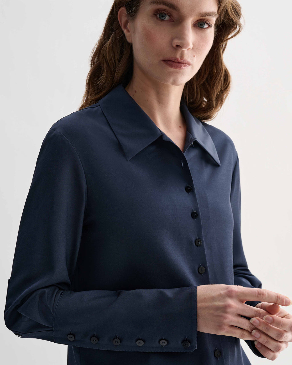 Model wearing Livia Silk Shirt in Petrol Blue, showcasing delicate front buttons and elongated buttoned cuffs