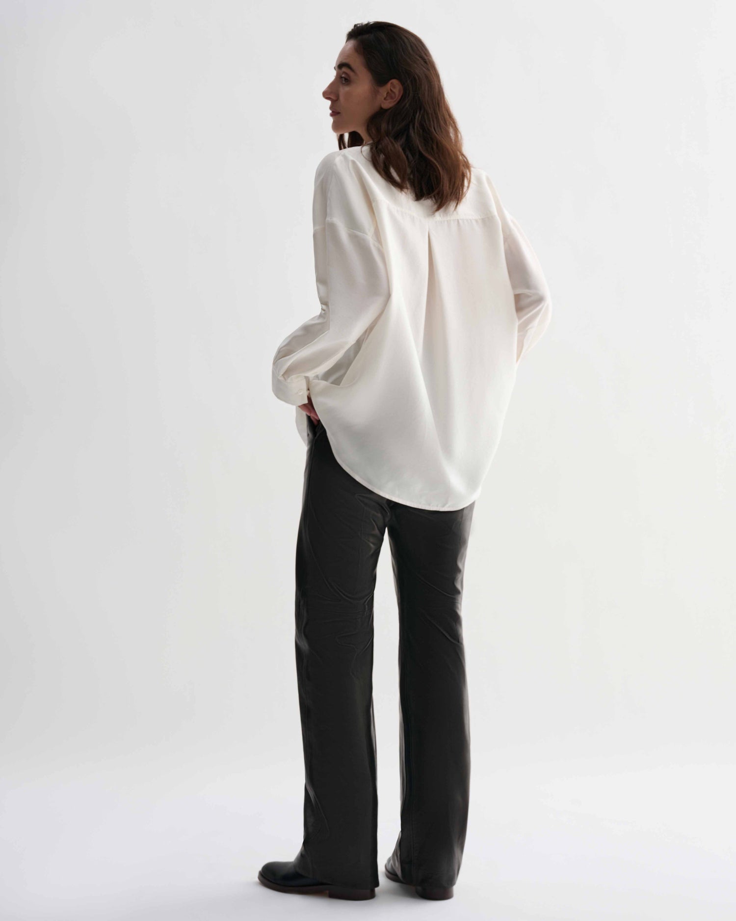 Off-white silk Maren shirt by Veronica De Piante, shown on a hanger with smooth fabric and elegant drape.