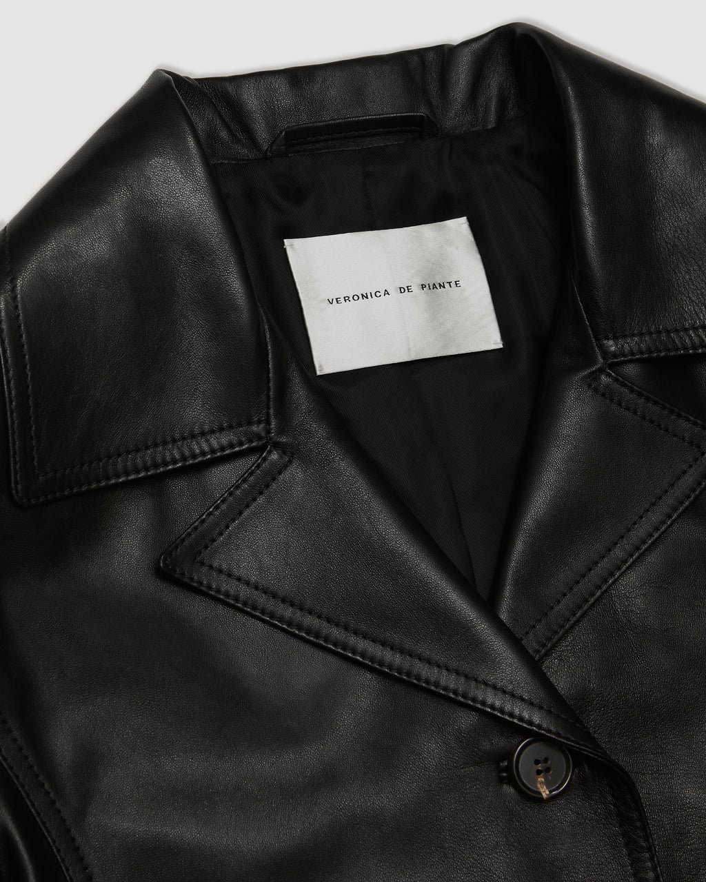 Black Blaire jacket in Nappa leather by Veronica De Piante, shown on a hanger with detailed leather texture and sleek design.