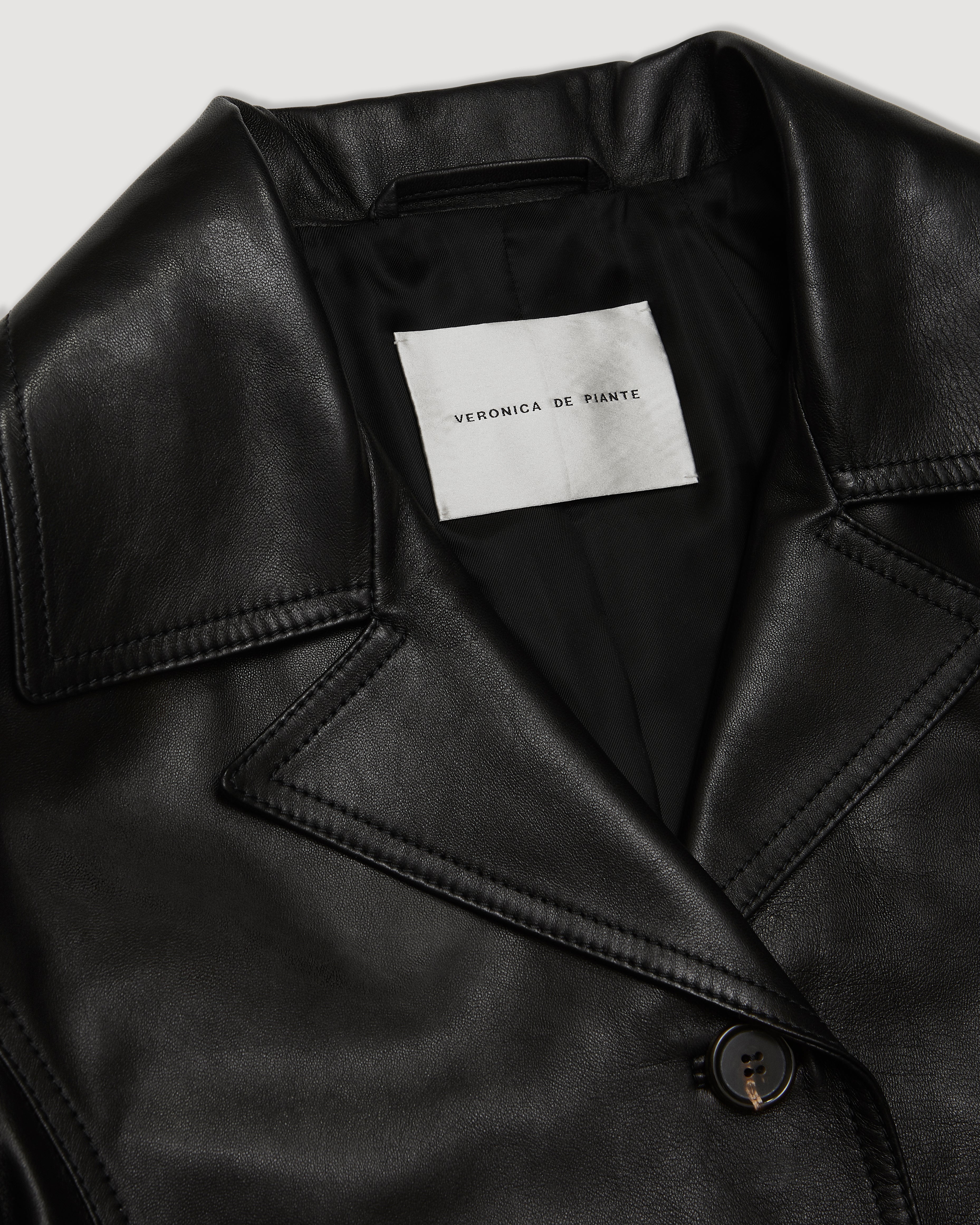 Black Blaire jacket in Nappa leather by Veronica De Piante, shown on a hanger with detailed leather texture and sleek design.