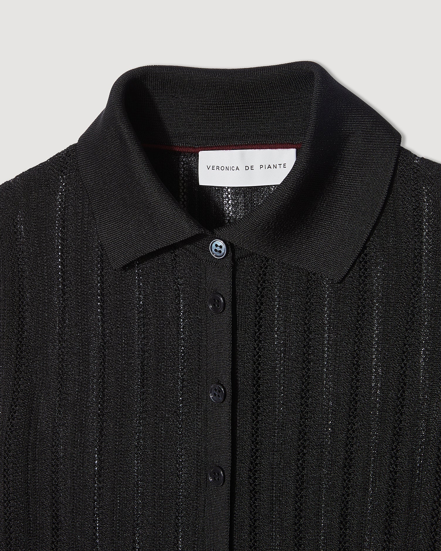 Black Lydia Polo in silk crepe knitwear by SALE, featuring a classic polo collar and smooth fabric texture.