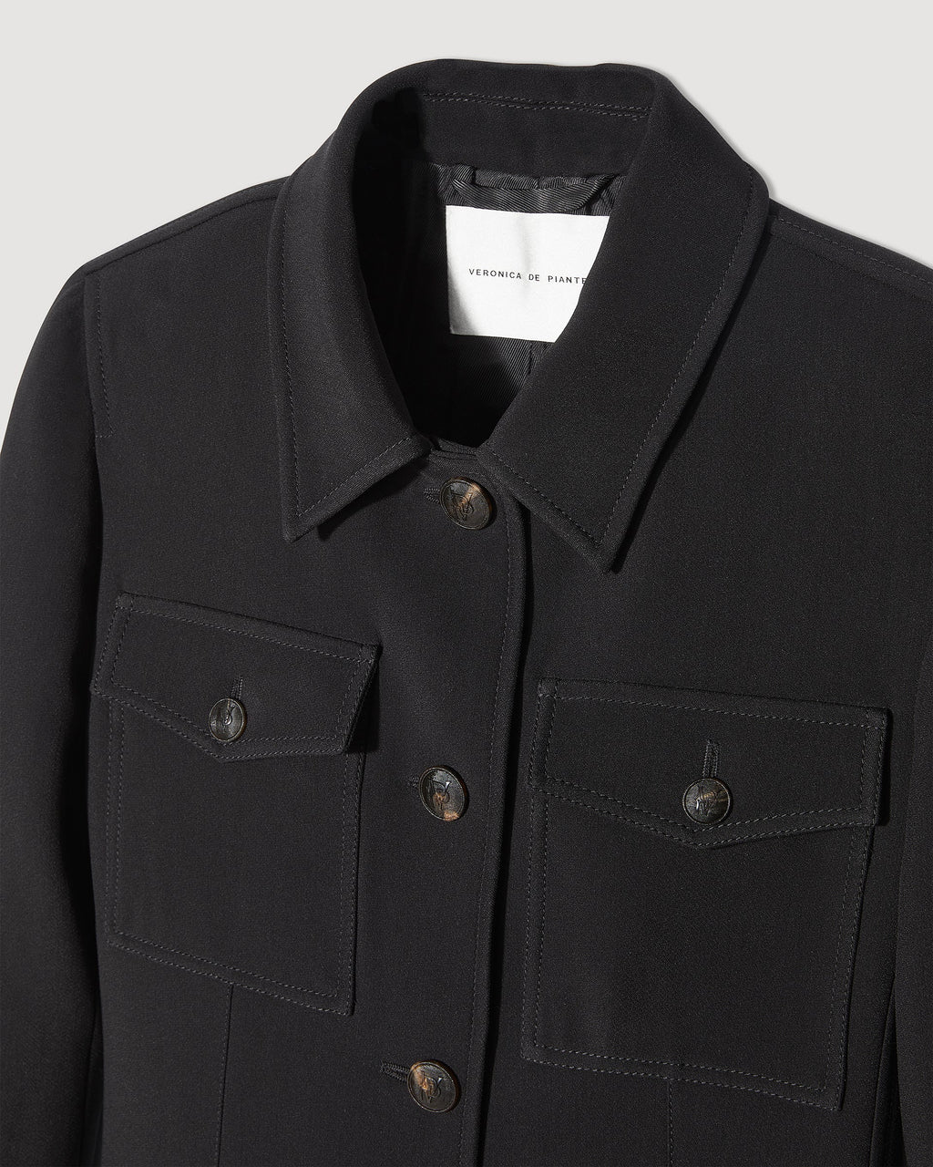 Veronica De Piante Alma Black Viscose Crepe Jacket, stylish coat with tailored fit and sleek black fabric, displayed on a hanger.
