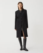 Black wool Manon coat by Veronica De Piante displayed on a hanger, showcasing its tailored design and elegant silhouette.