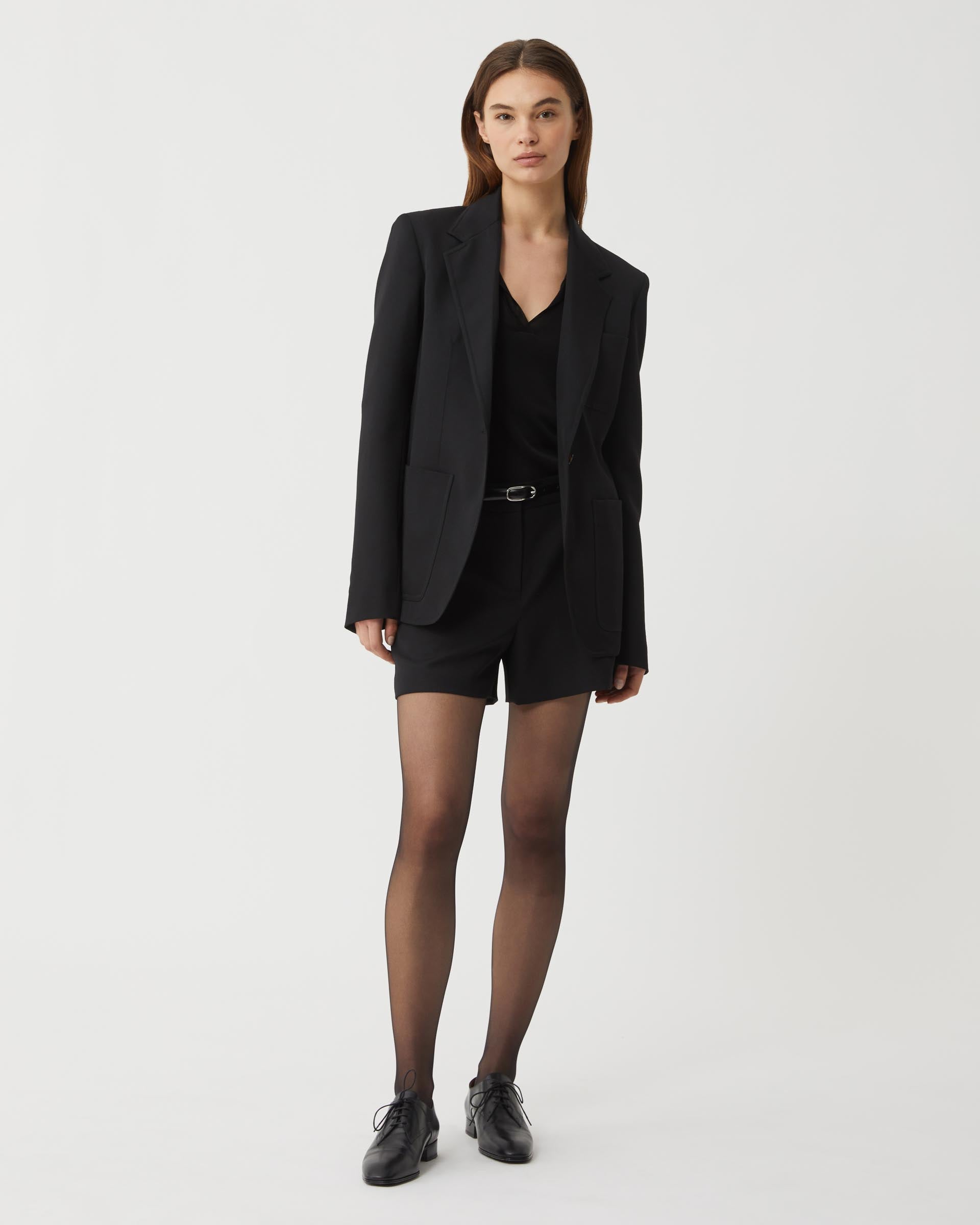 Black Faye Wool Jacket by Veronica de Piante, shown on a hanger, featuring a tailored coat design with a classic collar.