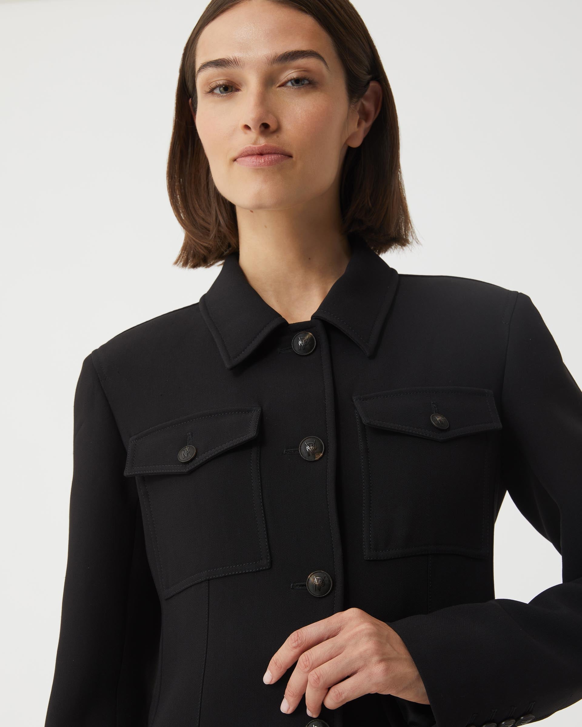 Black Alma jacket in viscose crepe by Veronica De Piante, shown on a hanger with a sleek, tailored silhouette.