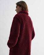 Romy bordeaux double-faced shearling coat, luxurious textured surface, tonal depth, generous volume, on model