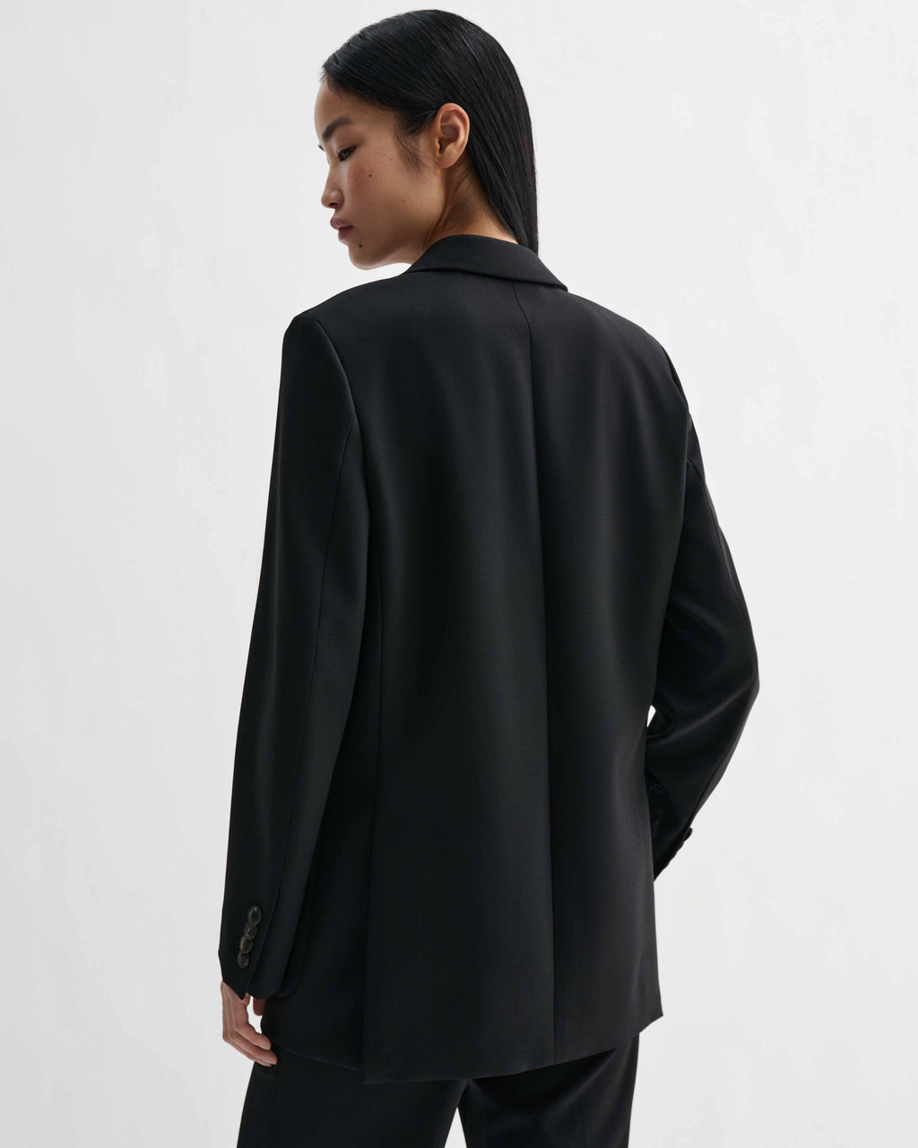 Sebastian black stretch wool twill blazer, structured straight fit with masculine cues, modeled from back view
