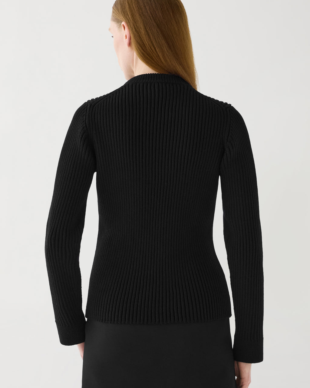 Black Ivy Merino wool ribbed knit sweater, semi-fitted long sleeve, worn by woman from back