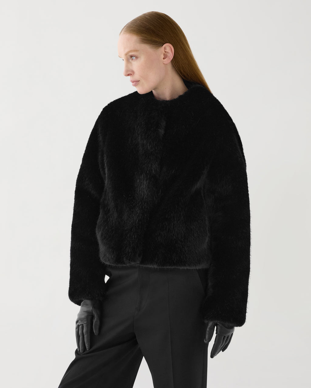 Black Sadie faux fur jacket worn by model. Cropped, boxy fit with plush texture and hidden hook-and-eye closure