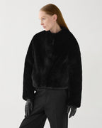 Black Sadie faux fur jacket worn by model. Cropped, boxy fit with plush texture and hidden hook-and-eye closure